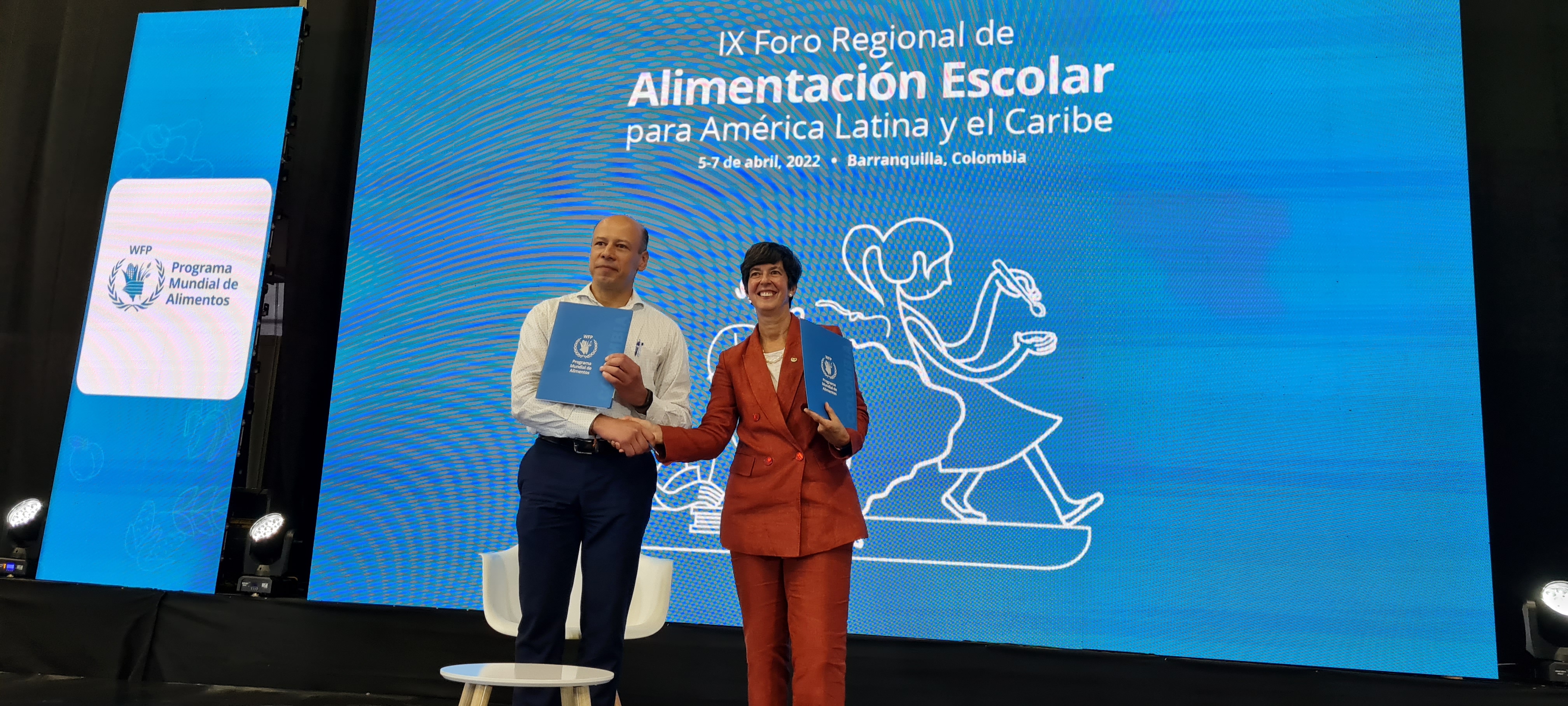La director regional del Programa Mundial de Alimentos, Lola Castro, (a la derecha) y el director de fortalecimiento territorial del Ministerio de Educación, Javier Medina, firman el acuerdo del noveno foro regional de alimentación escolar para América Latina y el Caribe en Barranquilla, Colombia.